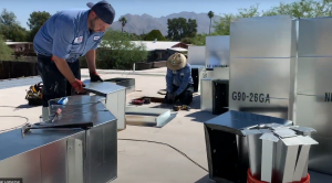 2 HVAC technicians proceeding with an air conditioning installation on a roof in Casas Adobes