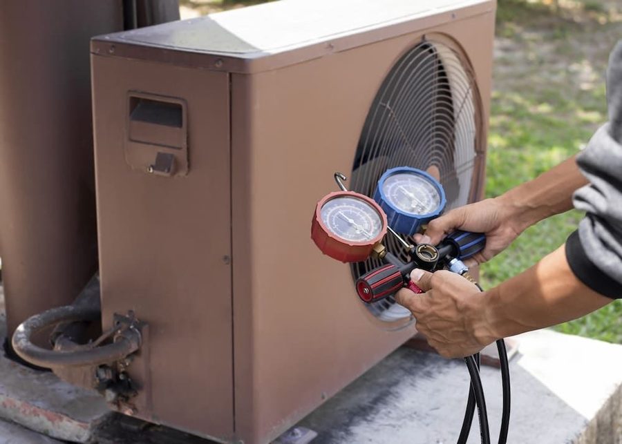 heat pump with technicians hands using manifold gauge