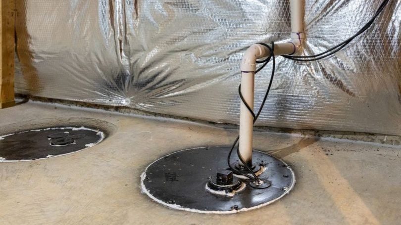 Basement sump pump system installed in a crawl space or basement to collect and remove groundwater, helping prevent flooding and water damage.